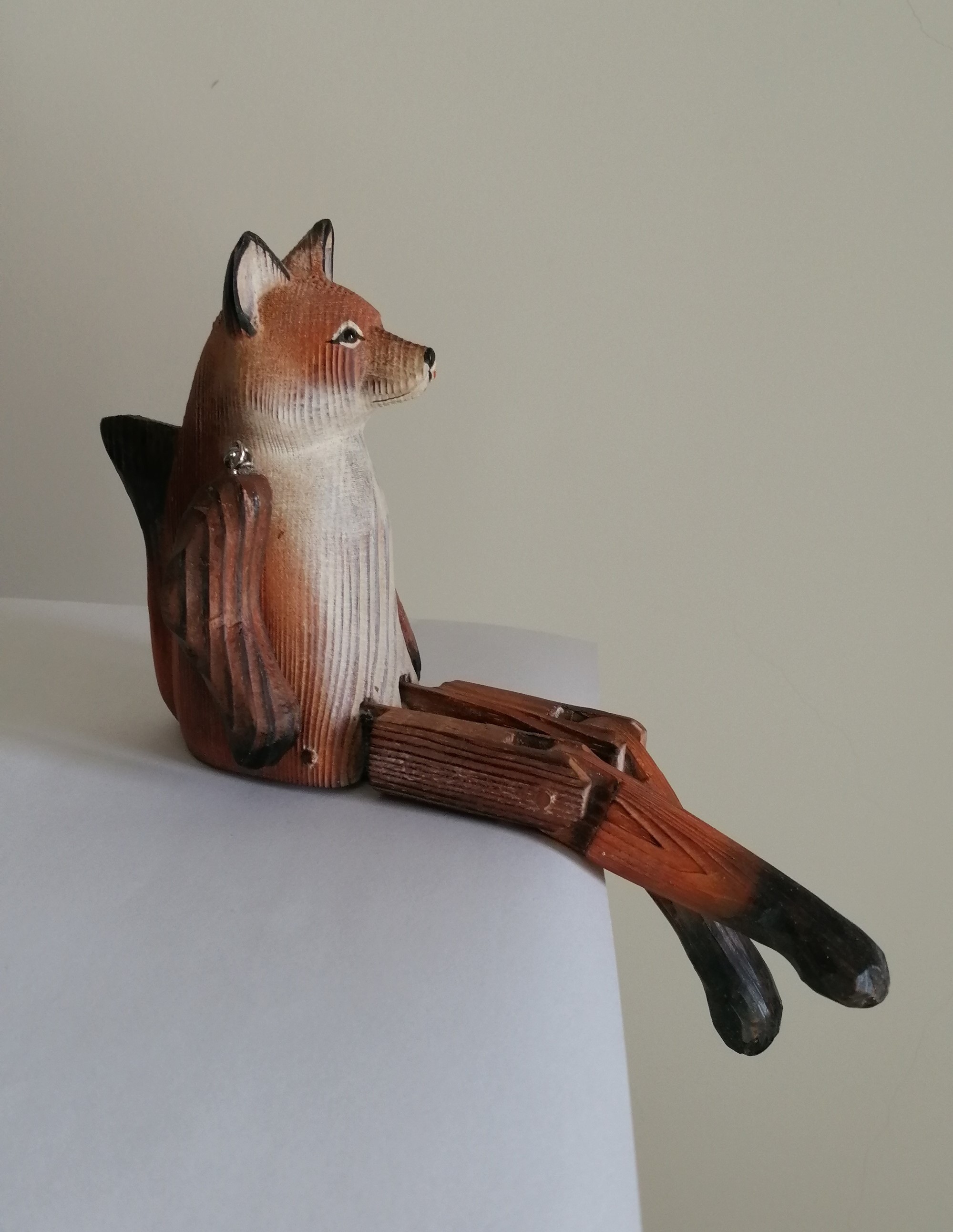 wooden carved sitting animal with dangly legs