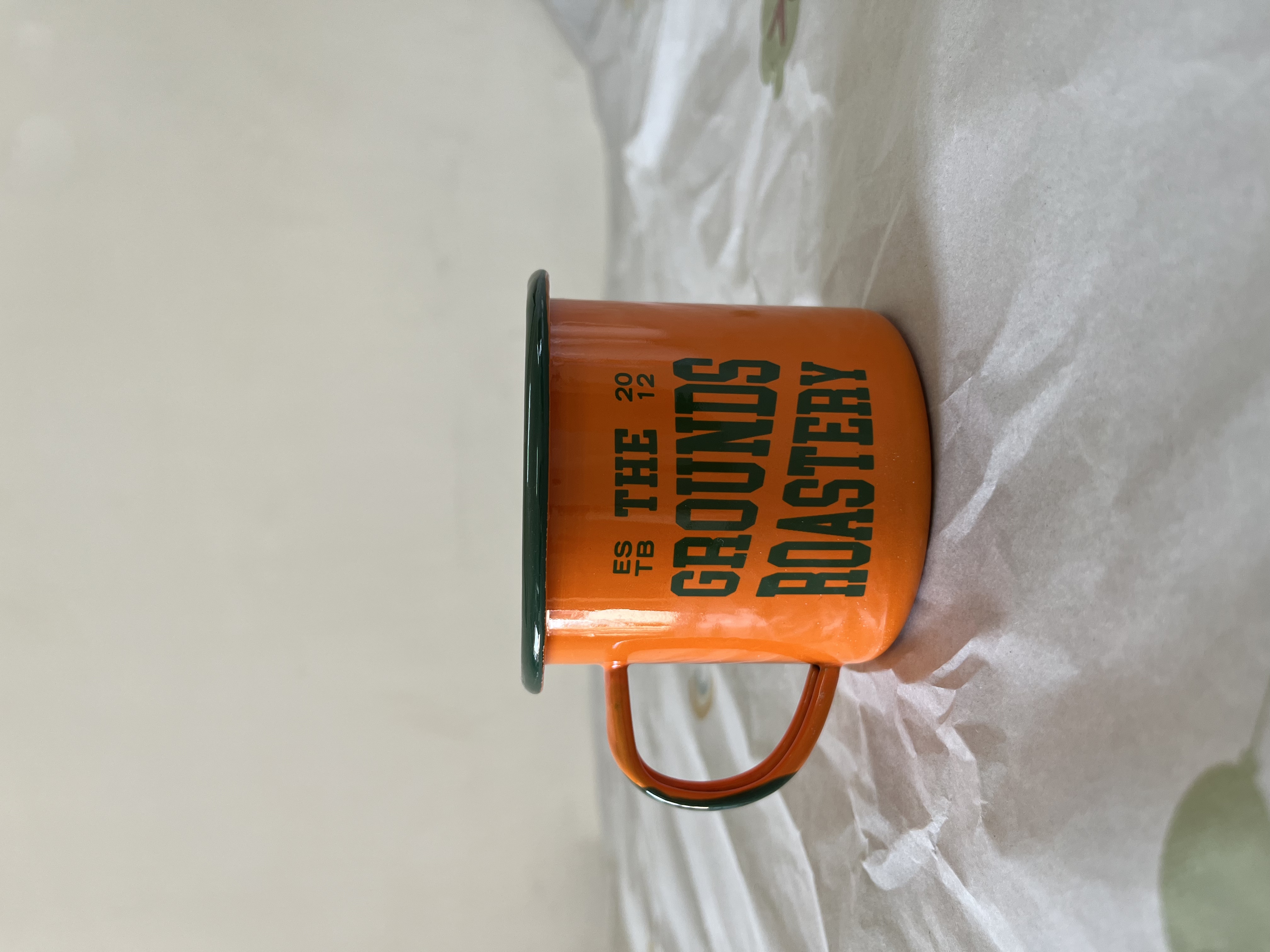 White inside and orange outside enamel mug with logo